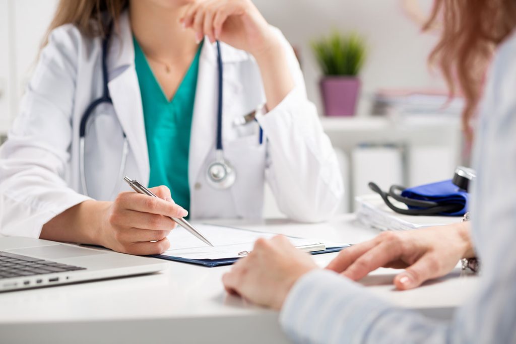 A doctor consulting a patient during basic health screening in Singapore.