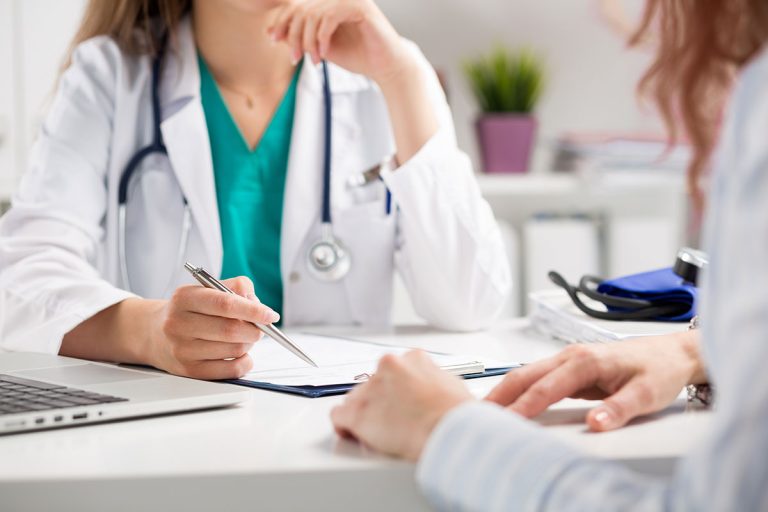 A doctor consulting a patient during basic health screening in Singapore.